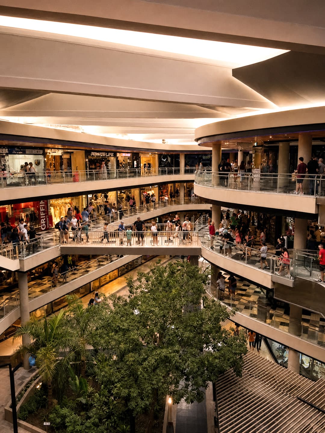 Interior de WO Shopping Villa Carlos Paz durante la tarde-noche, con sus balcones curvos y el paseo lleno de gente.
